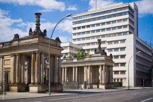 Fotografie An ancient building with baroque style colonnades next to a modern office building