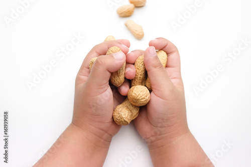 Children's Hand Holding Peanuts, isolated on a white background.