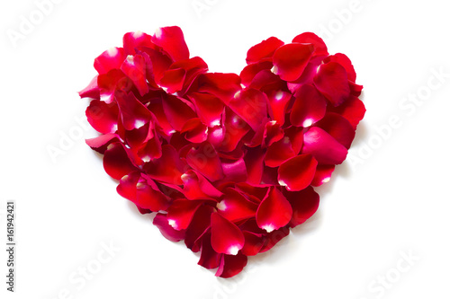 Rose petals are placed into a heart shape on a white background