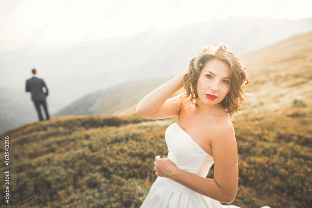 Happy beautiful wedding couple bride and groom at wedding day outdoors on the mountains rock. Happy marriage couple outdoors on nature, soft sunny lights Happy beautiful wedding couple bride and groom at wedding day outdoors on the mountains rock. Happy marriage couple outdoors on nature, soft sunny lights