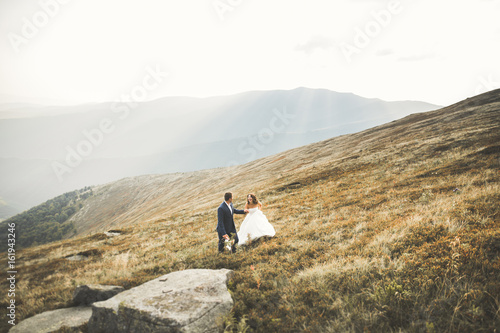 Wedding couple posing on sunset at wedding day. Bride and groom in love