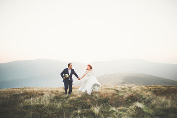 Beautifull wedding couple kissing and embracing near mountain with perfect view