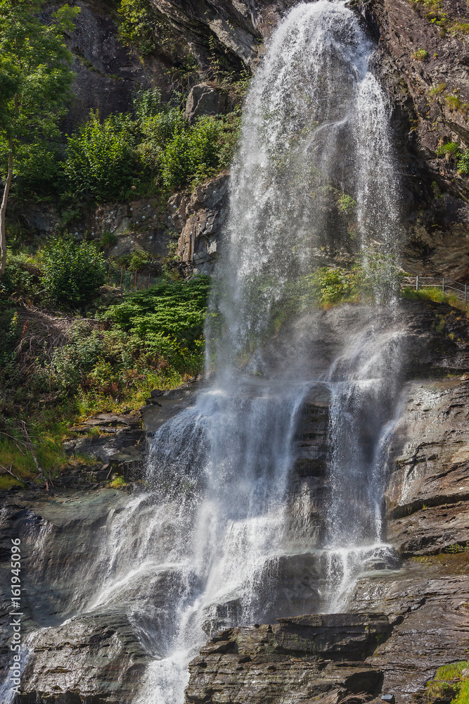 Tourist route passes right under the waterfall falling from steep cliffs, Norway Tourist route passes right under the waterfall falling from steep cliffs, Norway