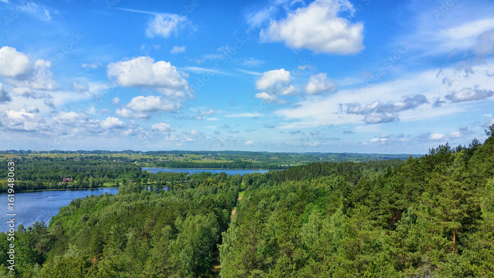 Picturesque view on the lake and forest at evening time just before the sunset. Sky and clouds reflected in water surface.Beautiful natural landscape. Panoramic view. The land of lakes. Europe. Picturesque view on the lake and forest at evening time just before the sunset. Sky and clouds reflected in water surface.Beautiful natural landscape. Panoramic view. The land of lakes. Europe.