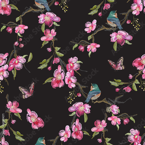 Embroidery floral seamless pattern with oriental cherry blossom and varied titmouse.