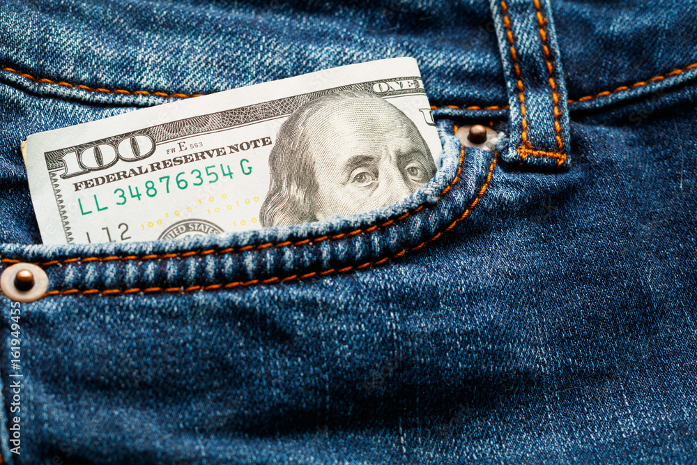 Hundred-dollar bill in jeans pocket. Close-up. Hundred-dollar bill in jeans pocket. Close-up.