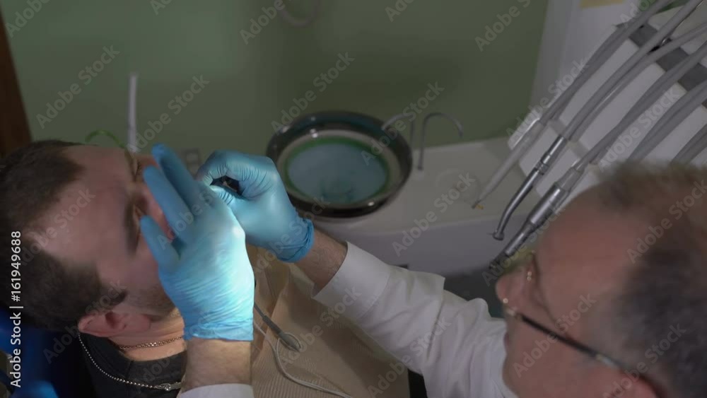 CloseUp,the Dentist Measures the Depth of the Root Canal of the