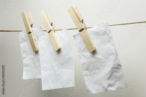 Paper sheets hanging, isolated on grey
