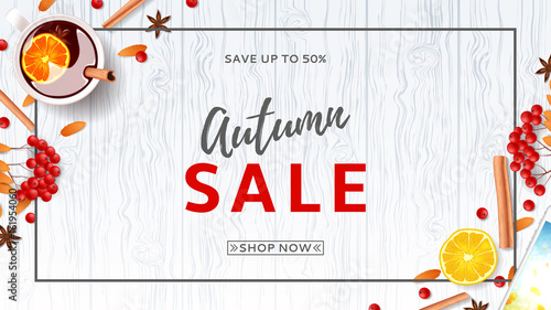 Beautiful web banner for autumn sale. Top view on composition with cup of mulled wine, rowan, cinnamon sticks on wooden texture. Vector illustration.