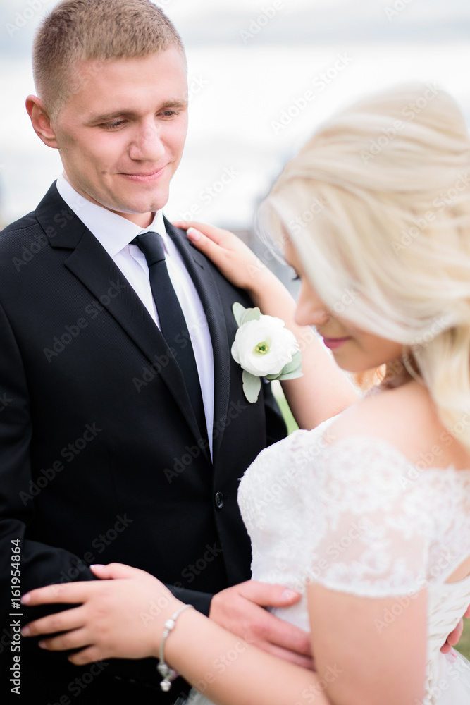 Smiling groom admires beautiful blonde bride Smiling groom admires beautiful blonde bride