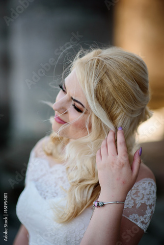 Bride touches her hair tender standing on the wind