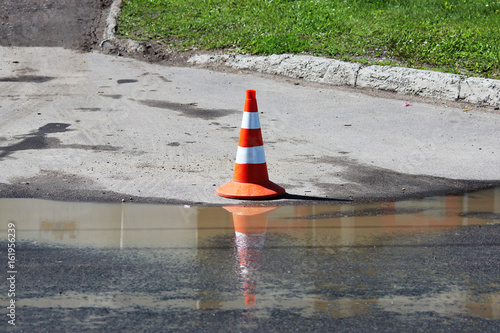 plastic signaling traffic cone encloses a place in the parking lot for trucks.