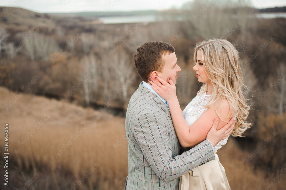 Portret of happy young couple hugging on the edge of the mountain Portret of happy young couple hugging on the edge of the mountain