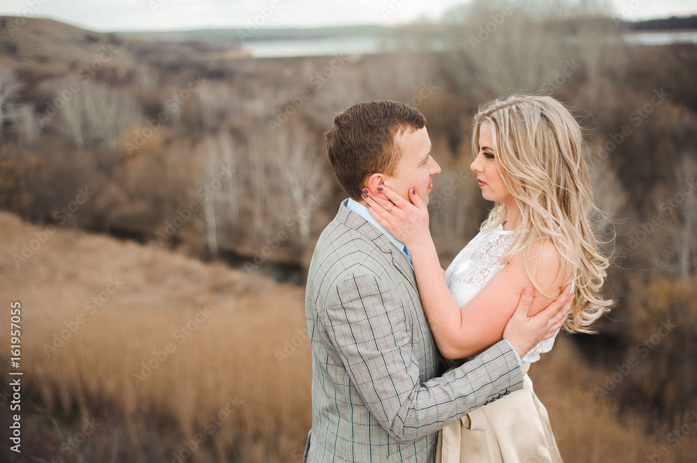 Portret of happy young couple hugging on the edge of the mountain