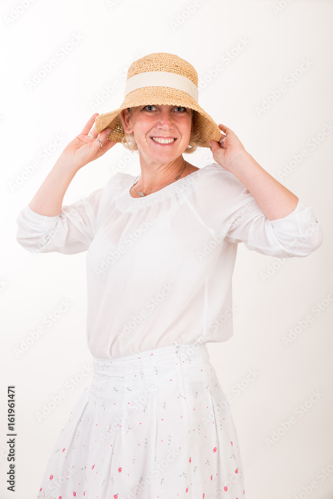 portrait of a attractive blond haired mid aged european woman wearing white dress and a beige summer head showin happy face - half body - studio shot on white background. portrait of a attractive blond haired mid aged european woman wearing white dress and a beige summer head showin happy face - half body - studio shot on white background.