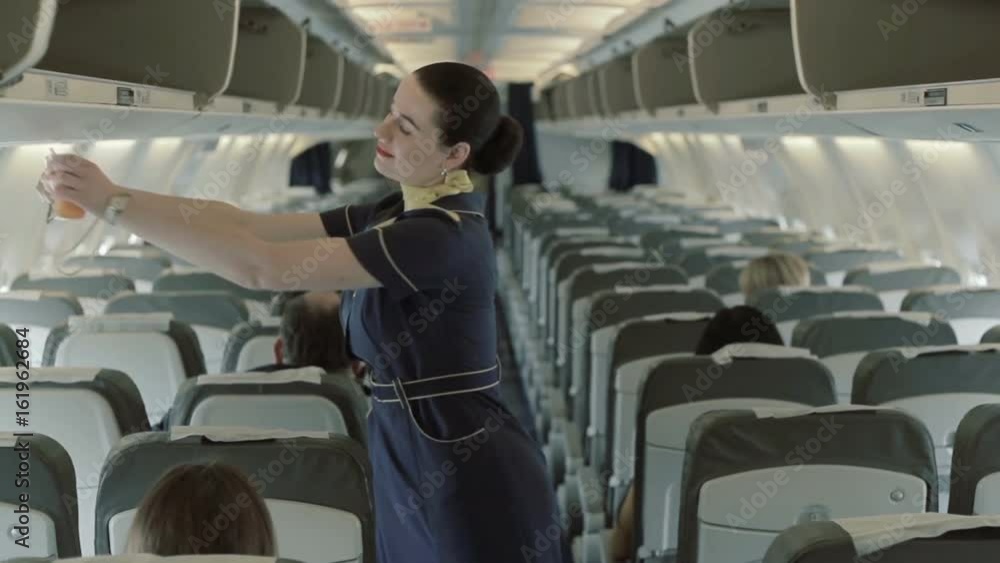 Young stewardess gives the instructions about oxygen masks