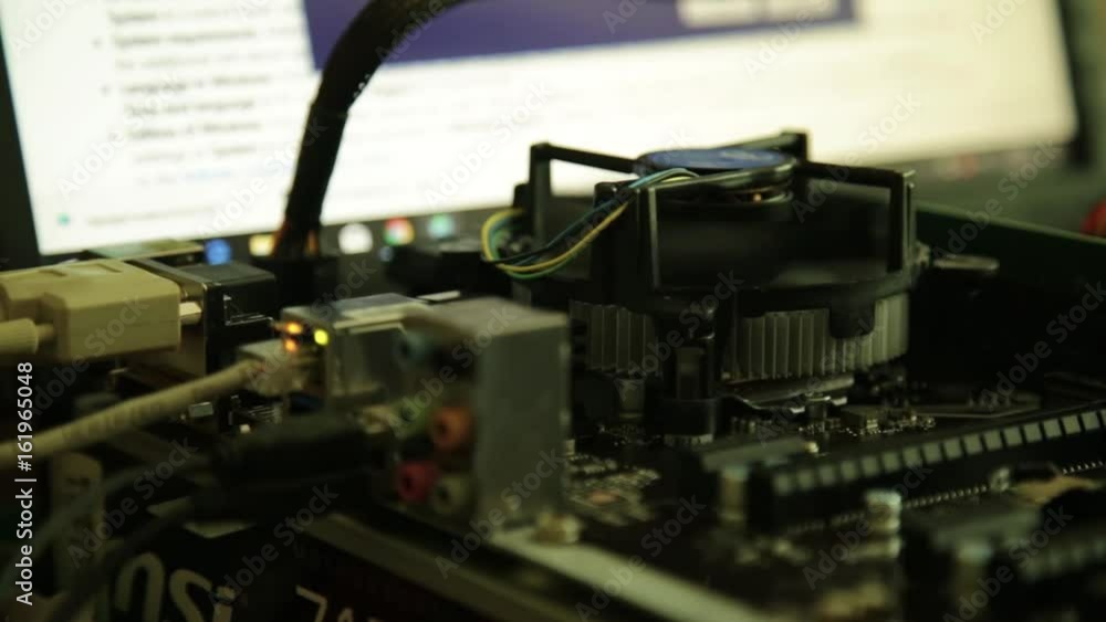 computer motherboard - processor fan and network card on a monitor background computer motherboard - processor fan and network card on a monitor background