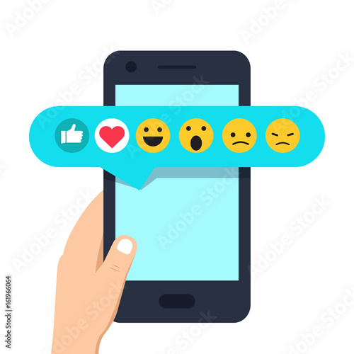 Human hand holding mobile phone with social network feedback emoticons : thumbs up, like, smile, angry, on screen.