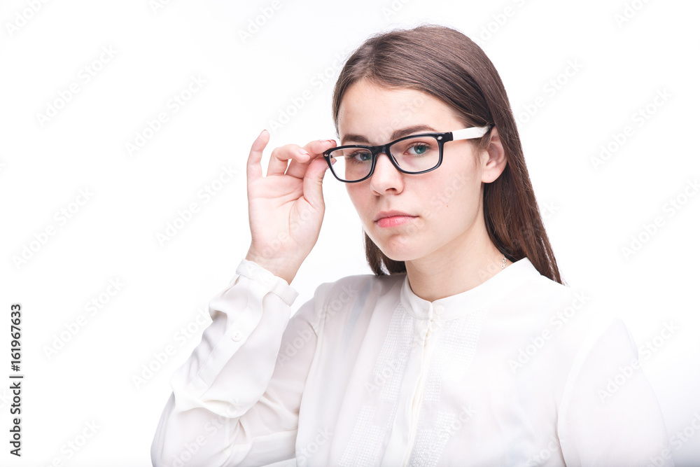 Beautiful young girl in glasses with a black rim a white shirt on an isolated background. Business concept Beautiful young girl in glasses with a black rim a white shirt on an isolated background. Business concept