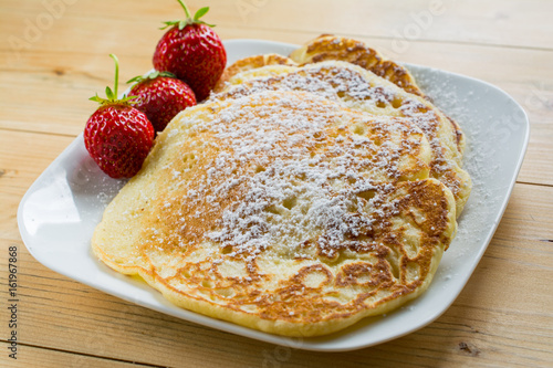 Home pancakes with fresh strawberry and sugar