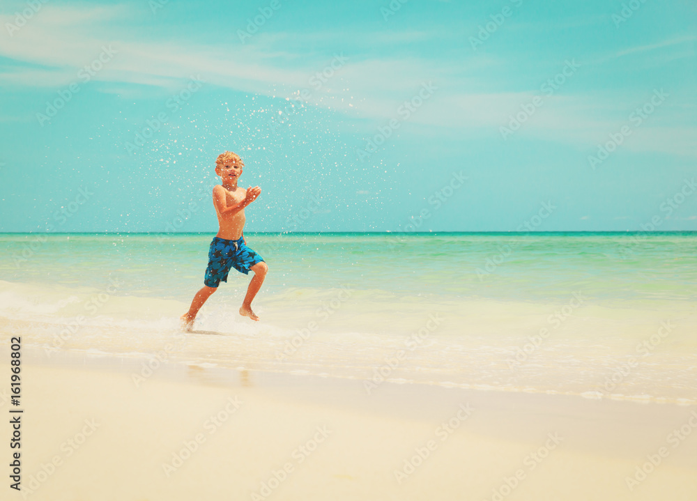 little boy run play with waves on beach