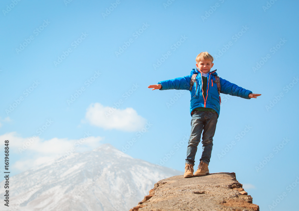 little boy hiking climbing in mountains