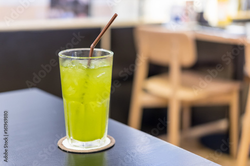 Iced Green tea with a straw on wood table