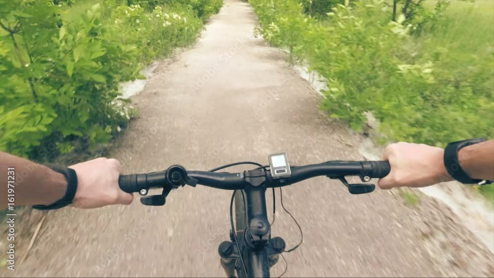 Trip to mountain bike from the first-person hand the wheel and road dust Trip to mountain bike from the first-person hand the wheel and road dust