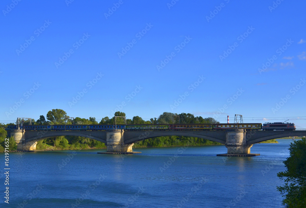 Passenger train on the railway bridge on the Rhone River between Tarascon and Beaucaire, France