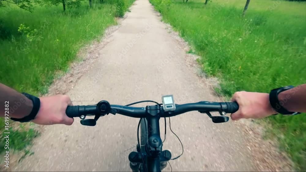 Trip to mountain bike from the first-person hand the wheel and road dust Trip to mountain bike from the first-person hand the wheel and road dust