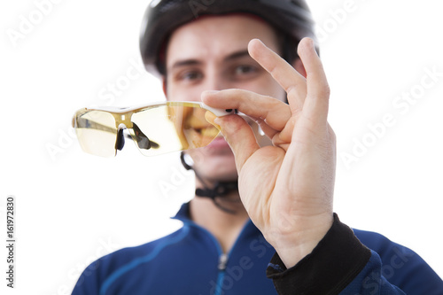 the cyclist holds the sports glasses