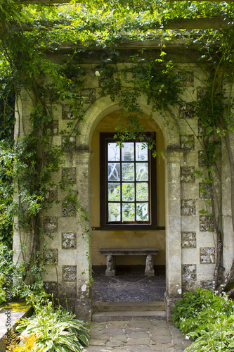 The ornate tiled decor and planting at the entrance to the gallery at the end of the world famous long pergola in the West Dean estate gardens