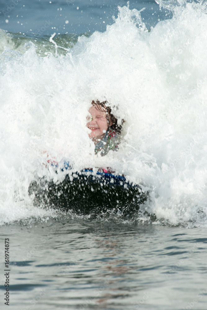 Young Girl surfing the waves on a boogy board