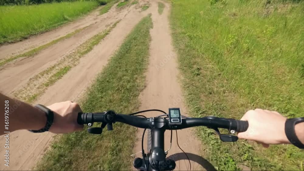 Trip to mountain bike from the first-person hand the wheel and road dust Trip to mountain bike from the first-person hand the wheel and road dust