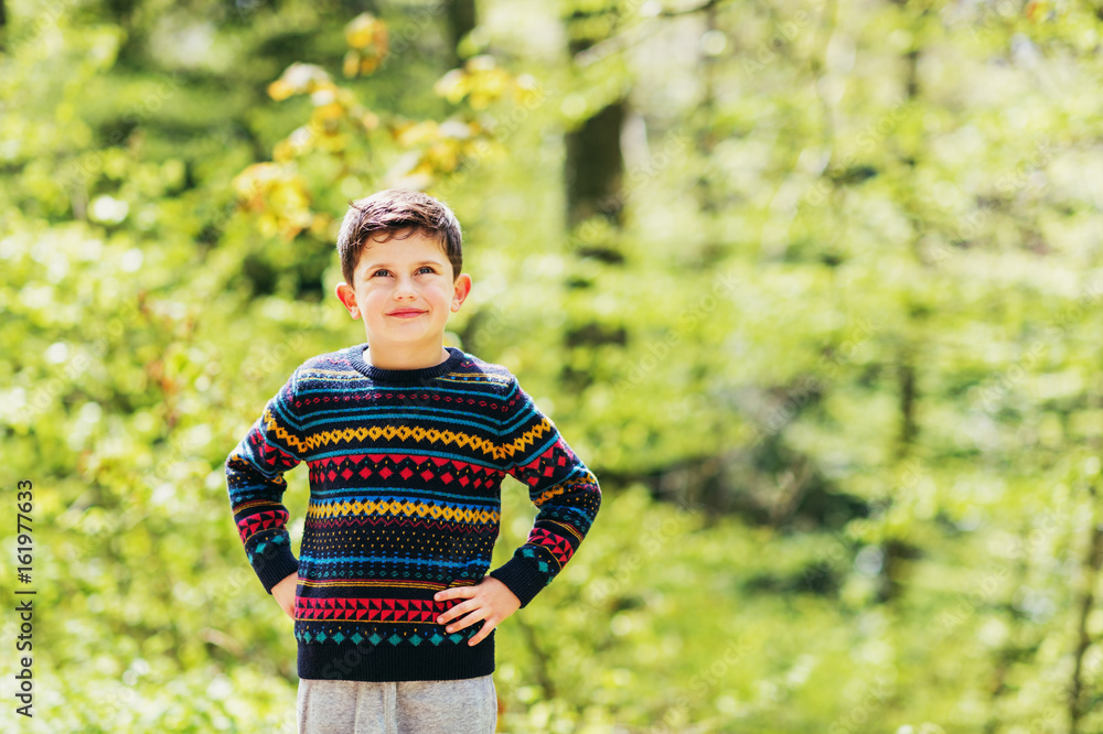 Cute little boy enjoying fresh spring forest, wearing warm colorful pullover Cute little boy enjoying fresh spring forest, wearing warm colorful pullover