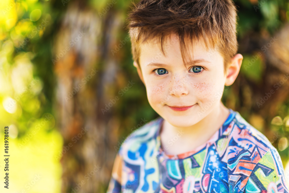Outdoor close up portrait of adorable 5-6 year old red-haired boy with freckles on his face Outdoor close up portrait of adorable 5-6 year old red-haired boy with freckles on his face