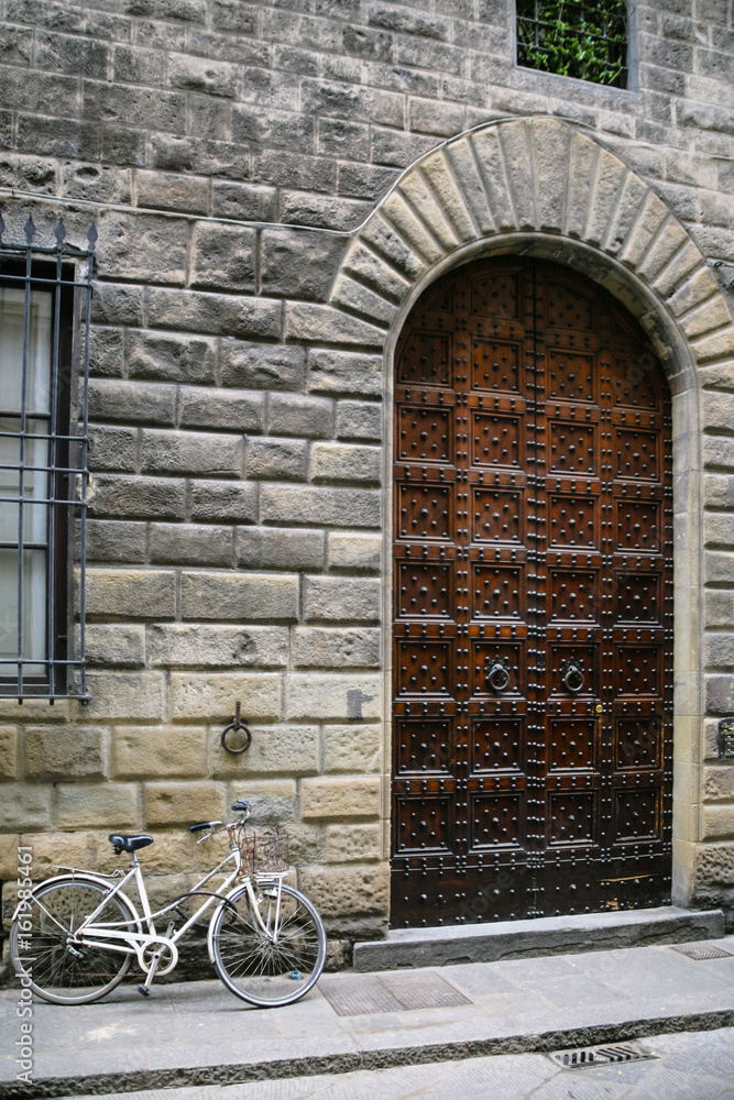 bicycle near door of medieval house in Florence