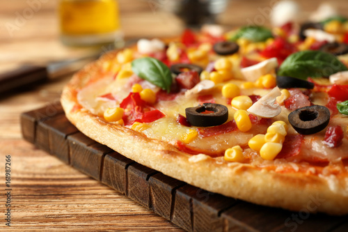 Close up view of tasty pizza on wooden table