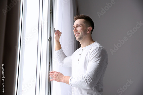 Smiling man opening white p...