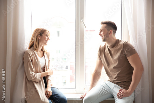 Couple sitting on sill near...