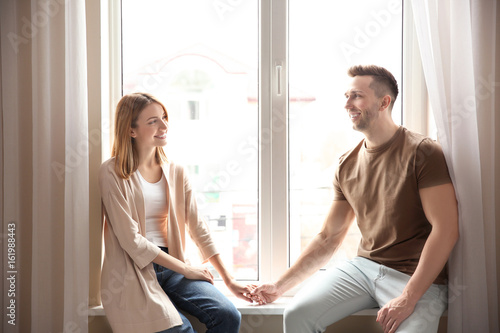 Couple sitting on sill near...