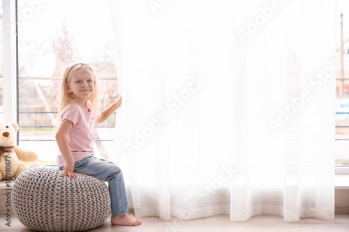 Small girl sitting on ottom...