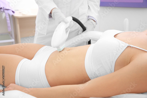 Young woman getting laser epilation in beauty salon