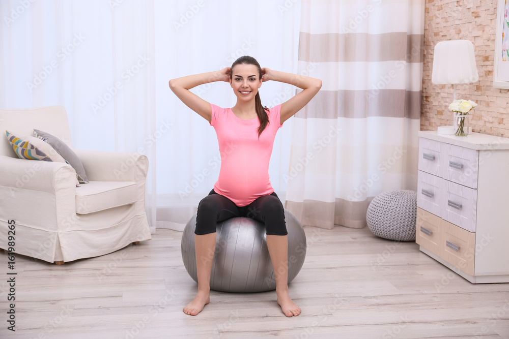 Beautiful pregnant woman doing exercise at home Beautiful pregnant woman doing exercise at home