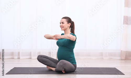Fototapeta Naklejka Na Ścianę i Meble -  Beautiful pregnant woman doing exercise indoors