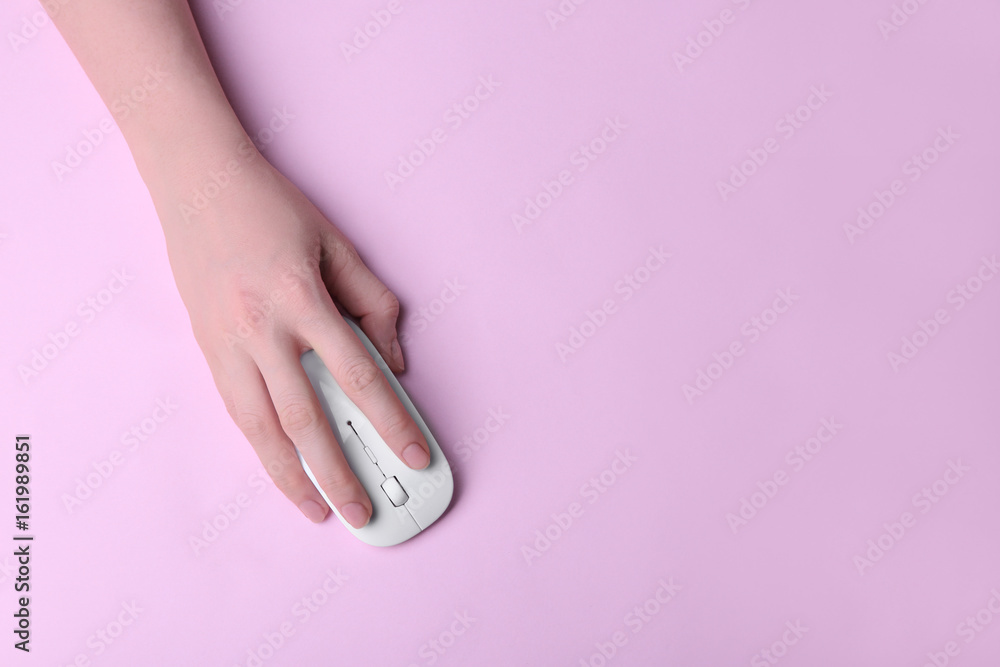 Fotografie Female hand holding computer mouse on pink background