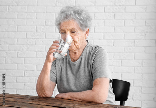 Elderly woman sitting and d...