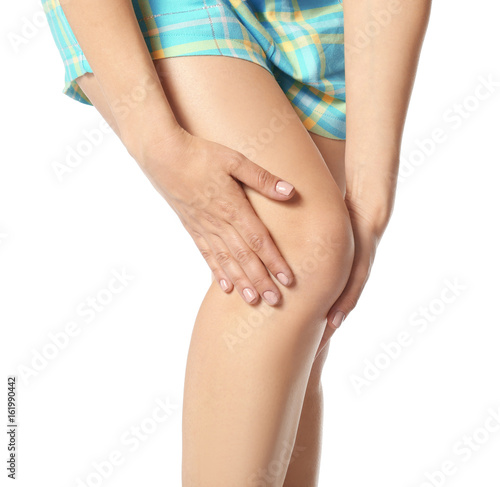 Young woman suffering from pain in leg on white background  closeup