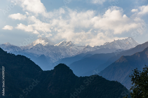 Kangchenjunga mountain with clouds above. Among green hills that view in the evening in North Sikkim, India.