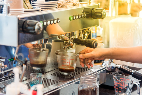 barista woman making coffee by espresso machine at caf  